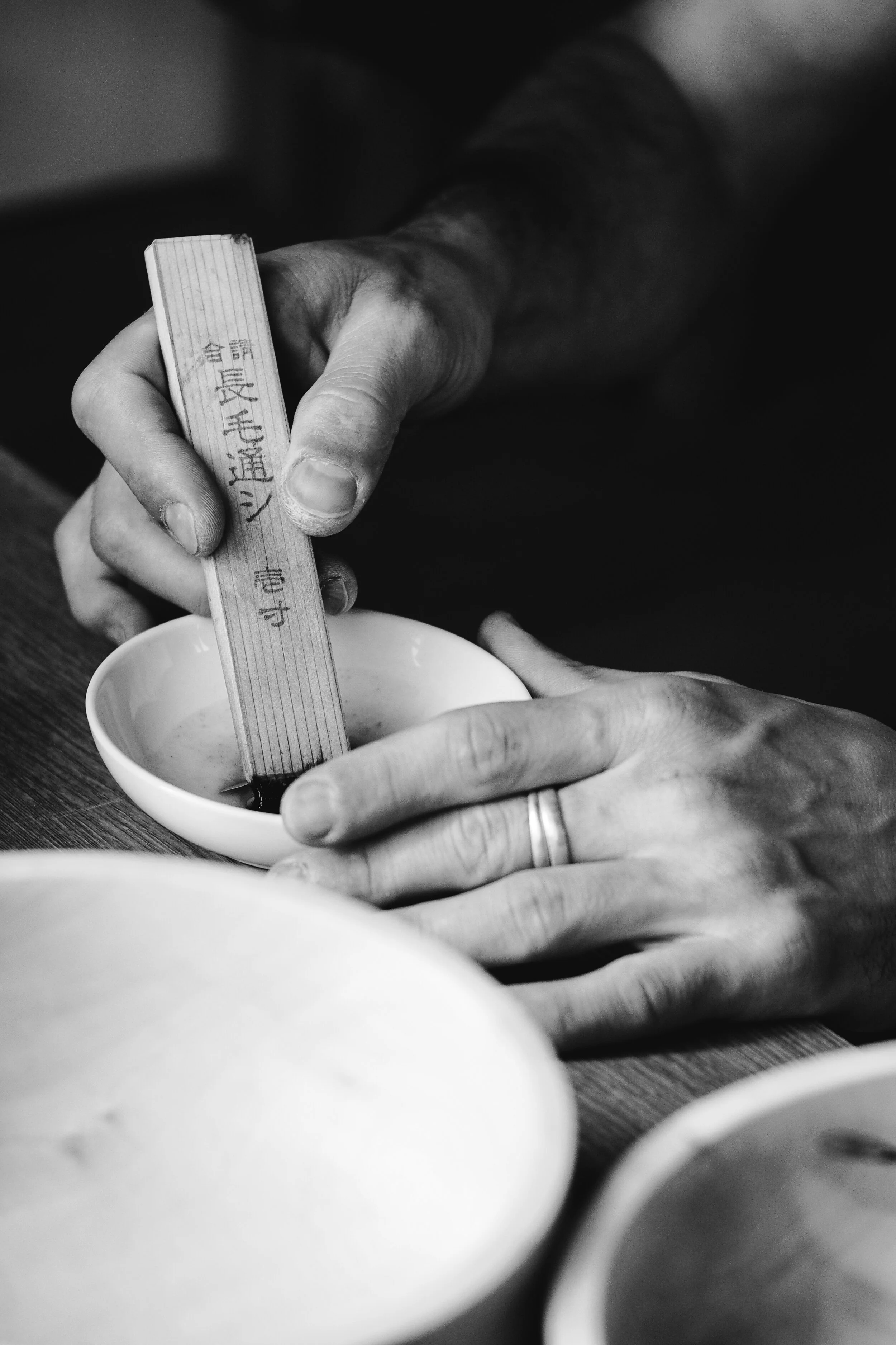 A brush loaded with urushi lacquer in the artist's hand
